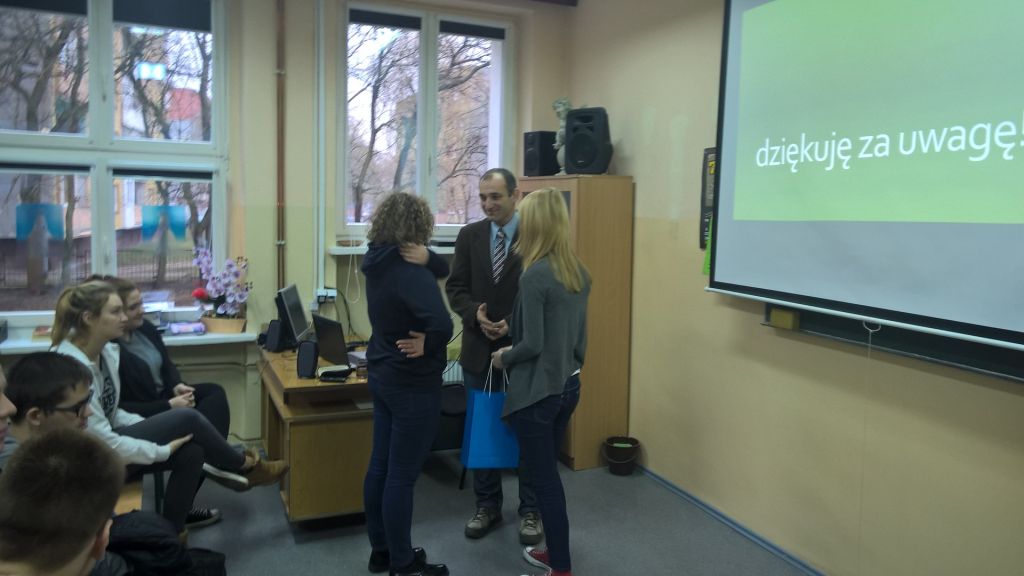 Uczniowie wręczają upominek dla wykładowcy