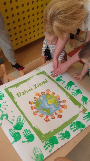 Dziecko odbija pomalowaną dłoń na plakacie