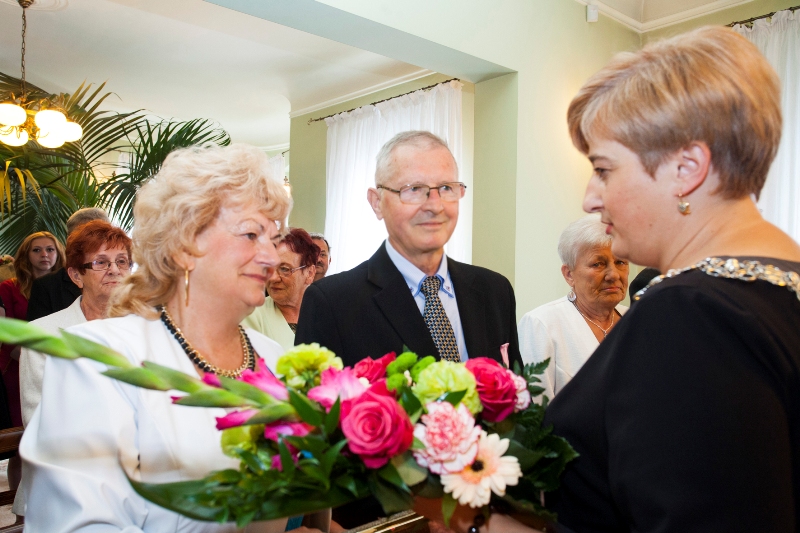 Kierownik USC wręcza kwiaty państwu: Hannie i Stanisławowi Obremskim