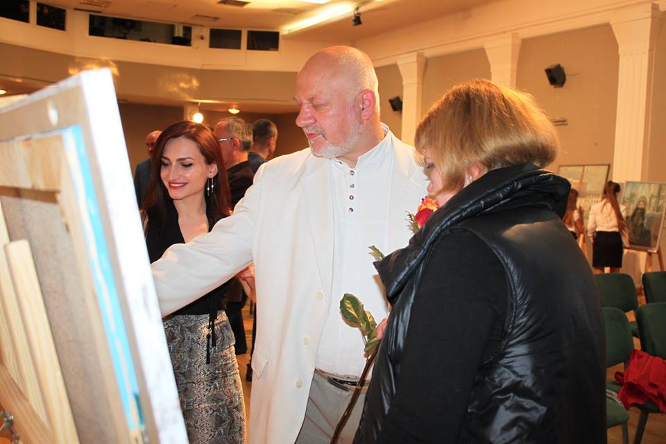 Powiększ zdjęcie. Jeden z artystów przed obrazem podczas wystawy poplenerowej