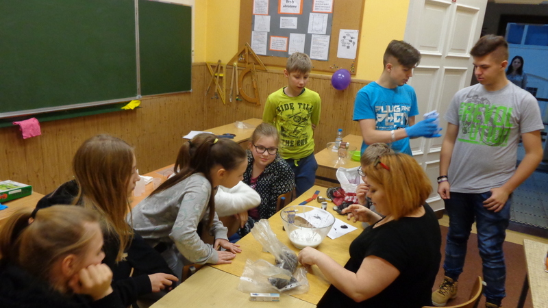Powiększ zdjęcie. Grupa uczniów uczestniczy w doświadczeniach