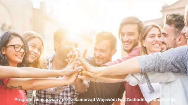 Powiększ zdjęcie. Uśmiechnięte osoby we wspólnym uścisku dłoni