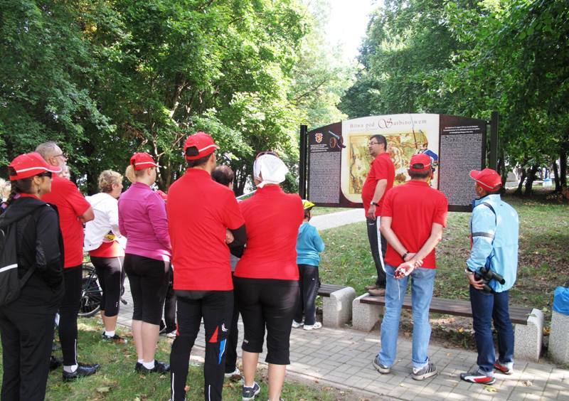 Przed tablicą informacyjną o bitwie pod Sarbinowem