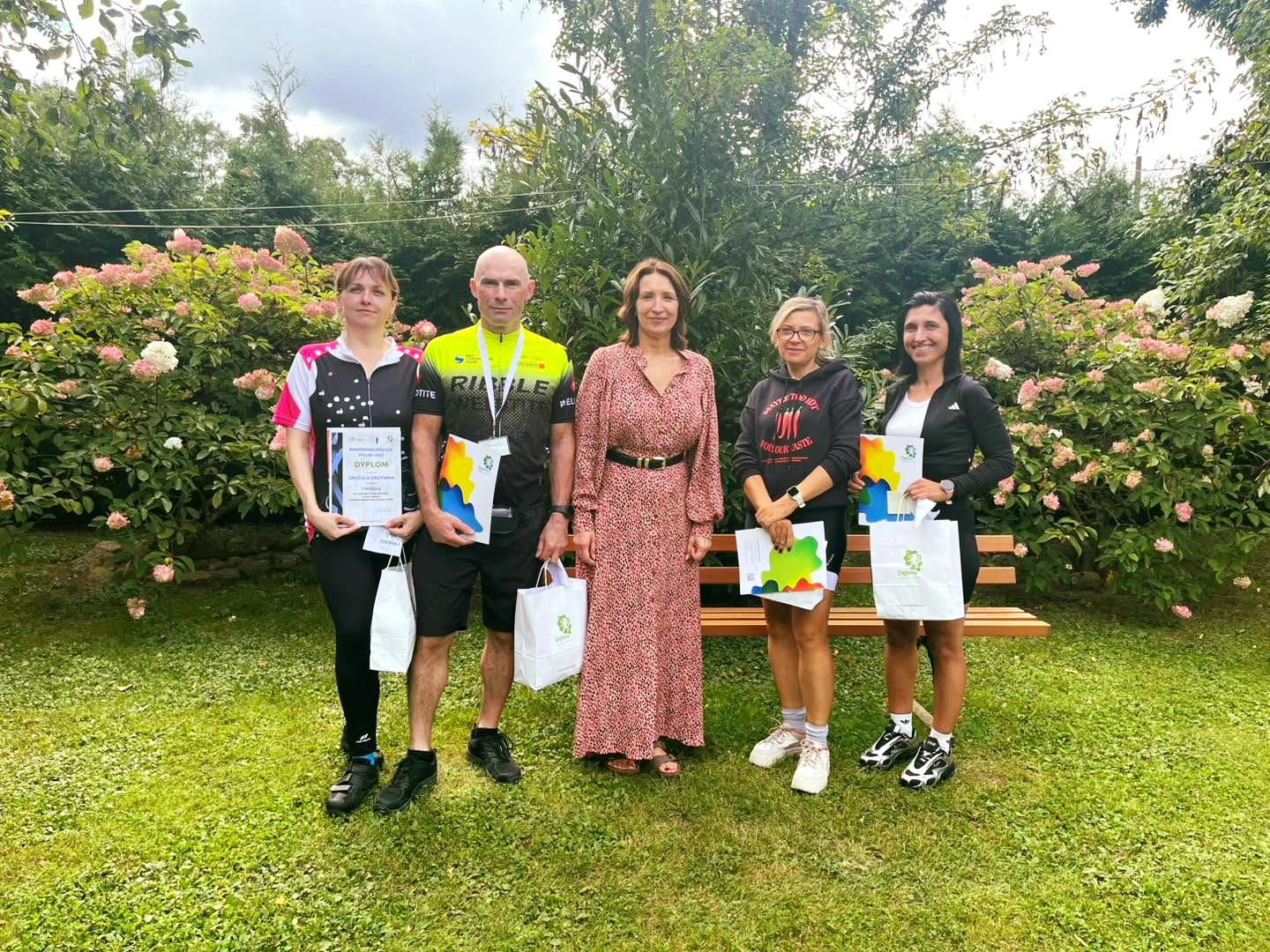Nagrodzeni rowerzyści, w środku stoi w sukience pani wiceburmistrz