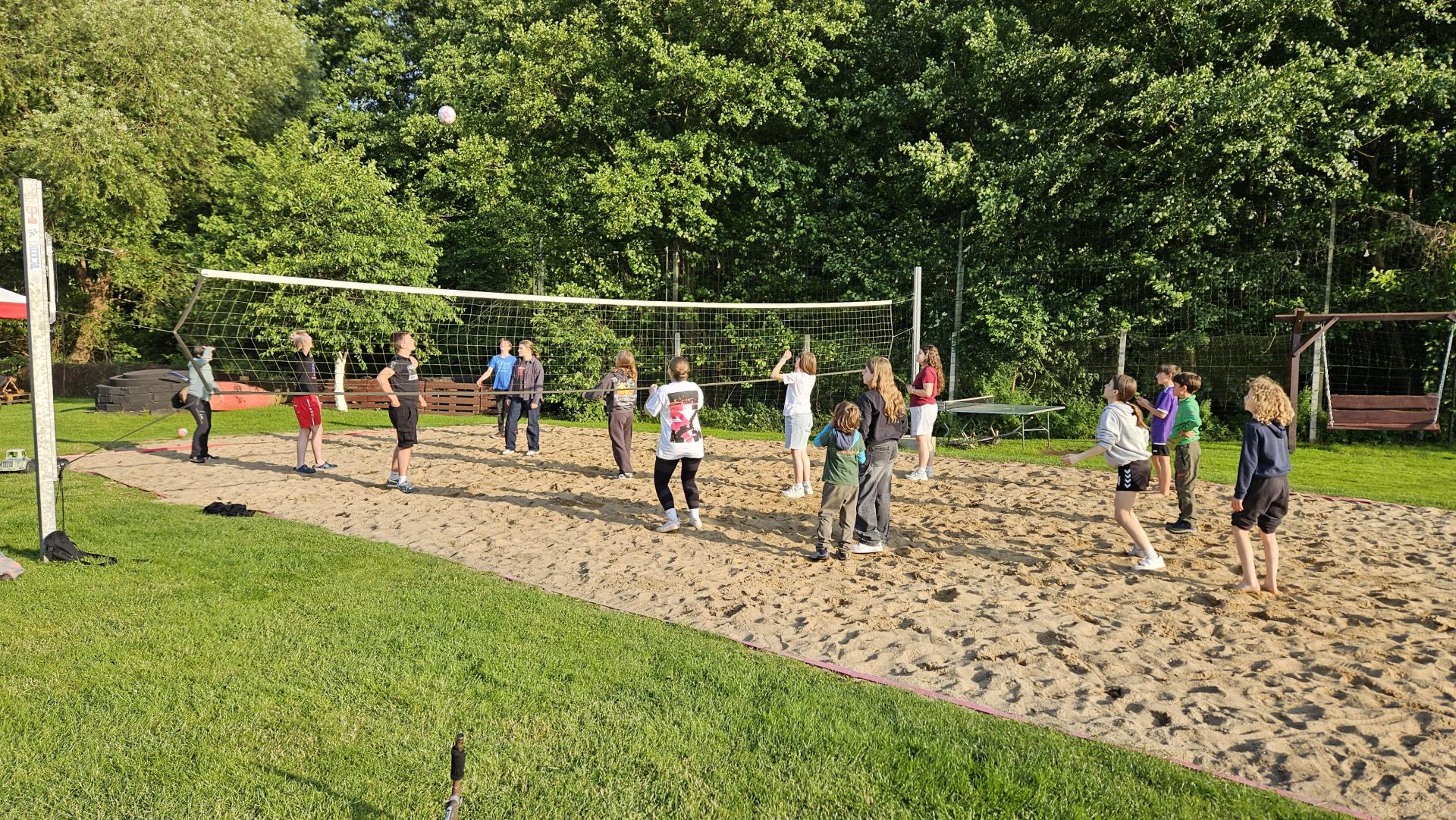 Dzieci rozstawione na boisku do siatkówki plażowej 