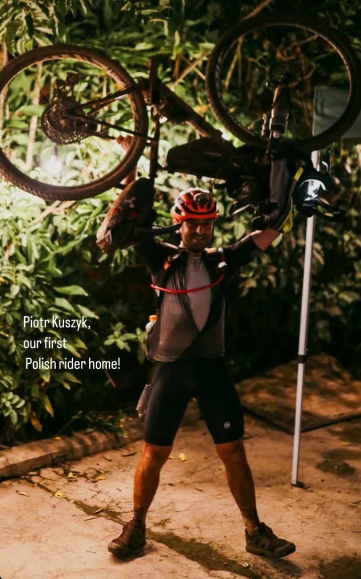 Piotr Kuszyk trzyma rower nad głową 
