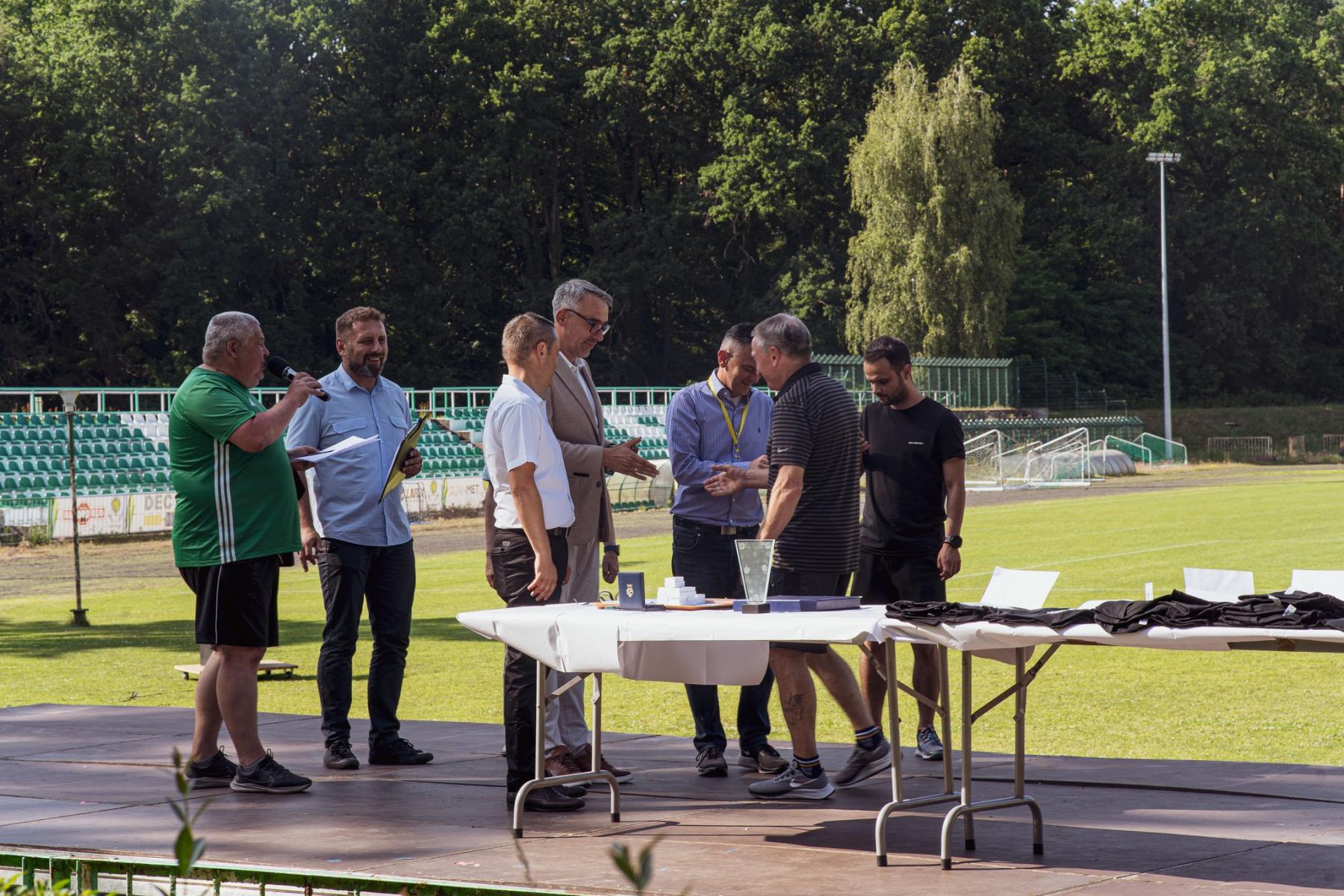 Grupa osób wręcza odznaczenia 