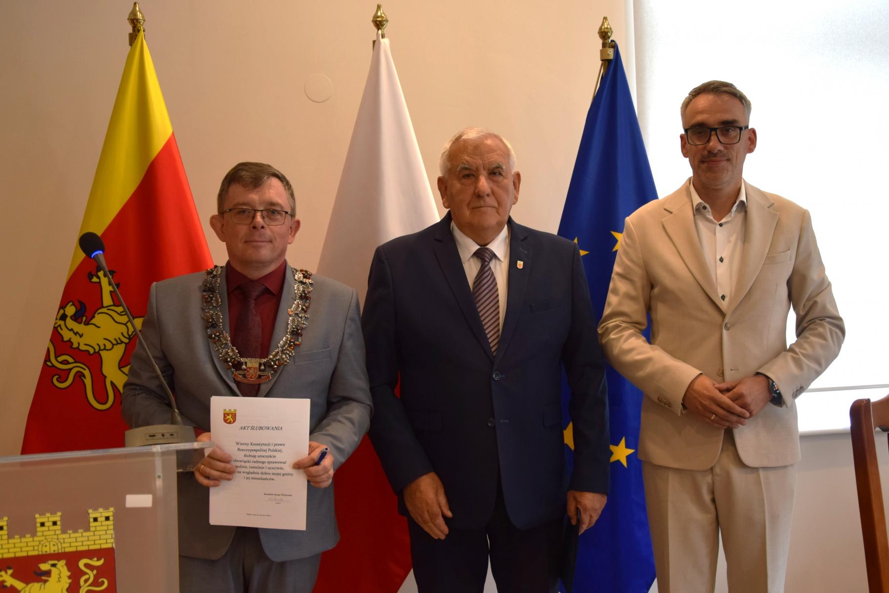 od lewej stoją: przewodniczący Rady, nowy radny, burmistrz Dębna