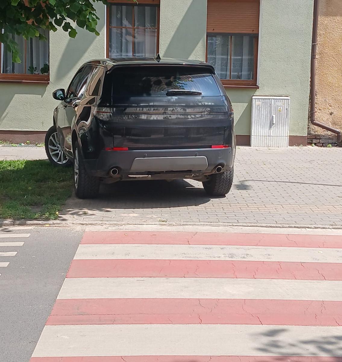 Samochód zaparkowany na chodniku przed przejściem da pieszych, ograniczające wejście na pasy