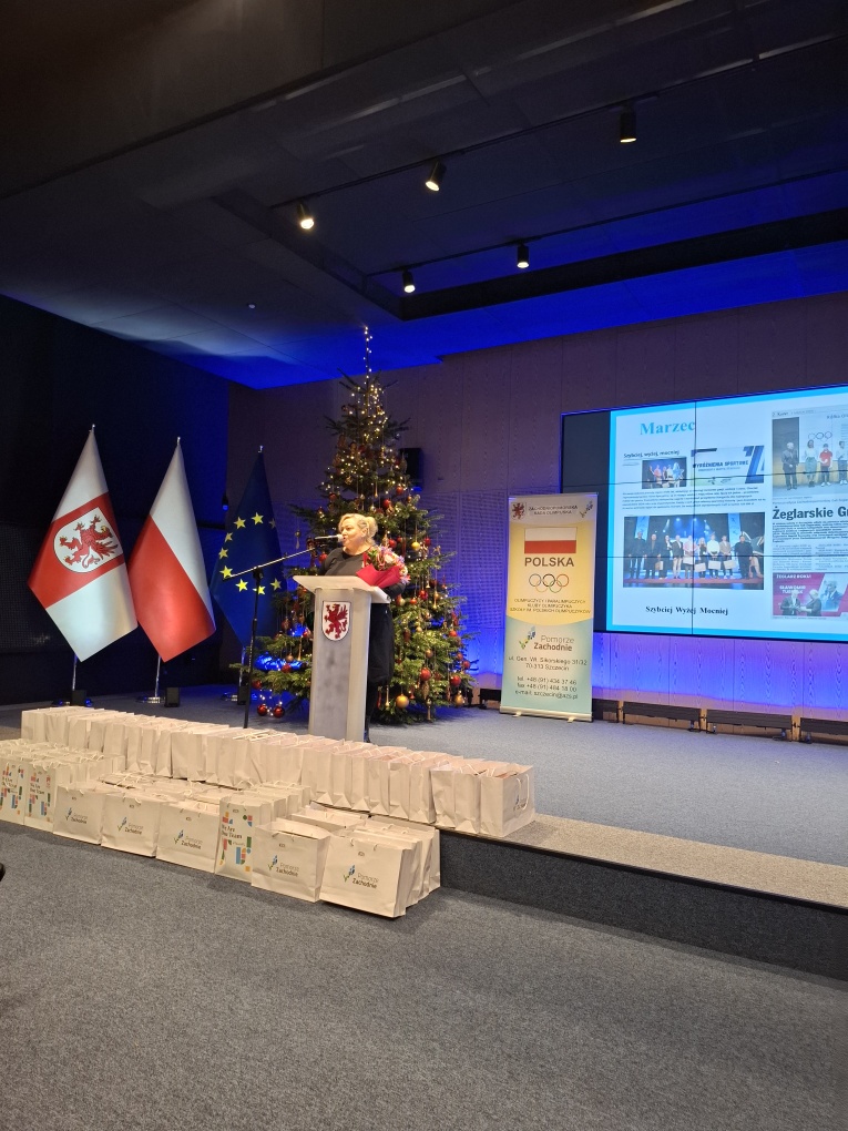 Kobieta stoi w sali przy m&oacute;wnicy 