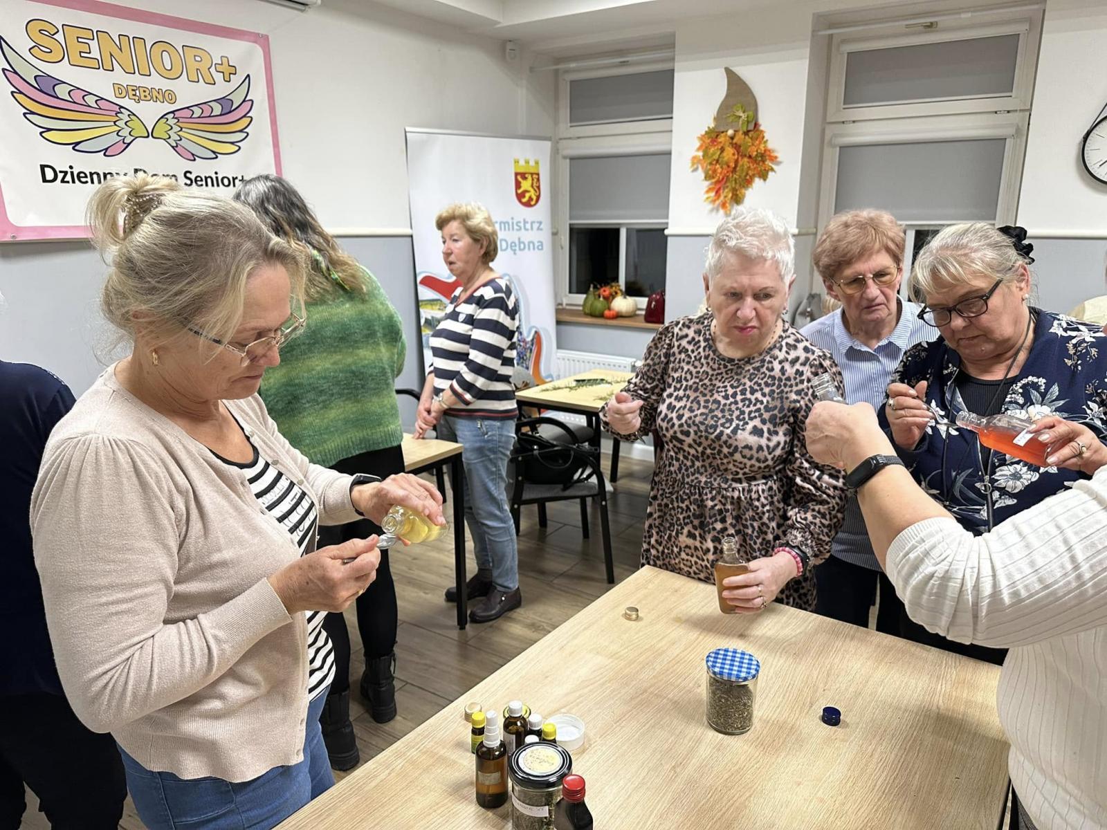 Seniorki w sali. trzymają łyżeczki, wsadzają do małych słoiczk&oacute;w. 