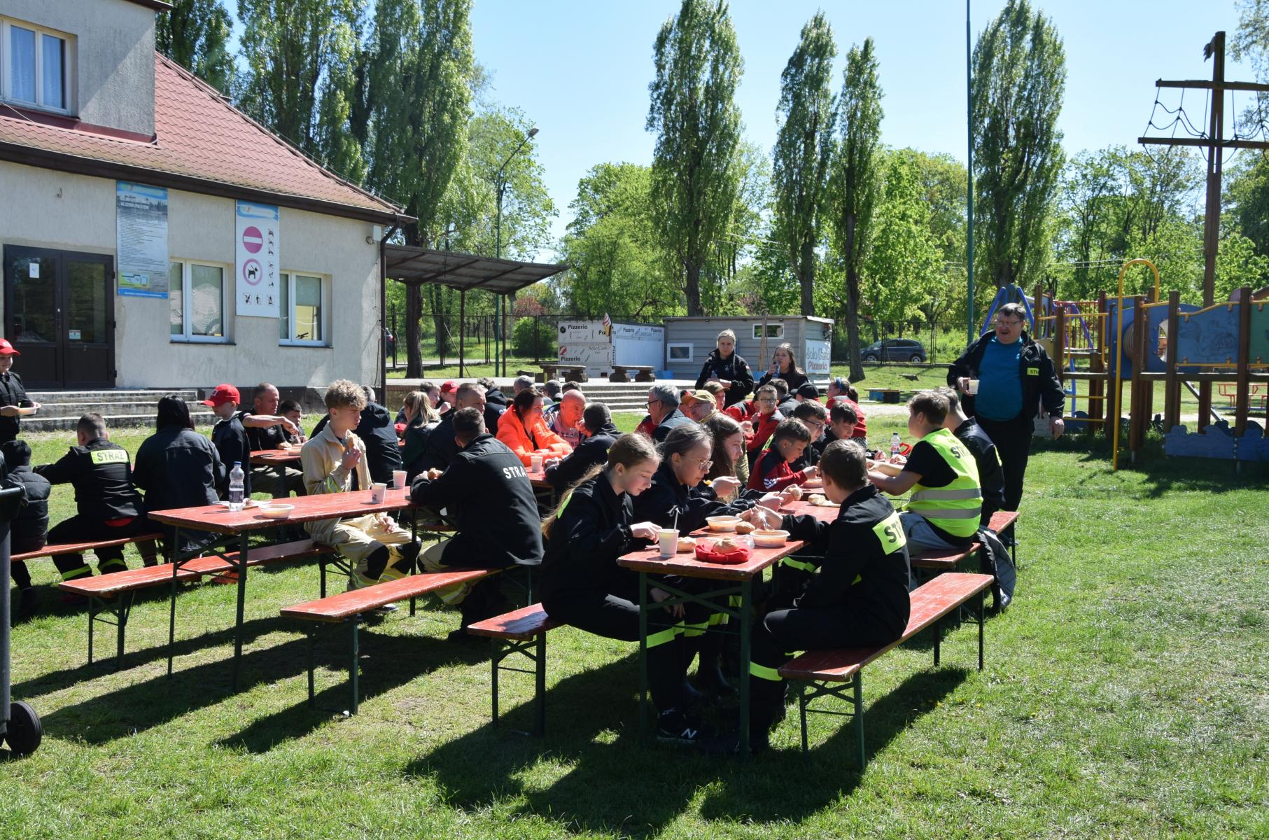 Ludzie siedzą przy stołach spożywają posiłek