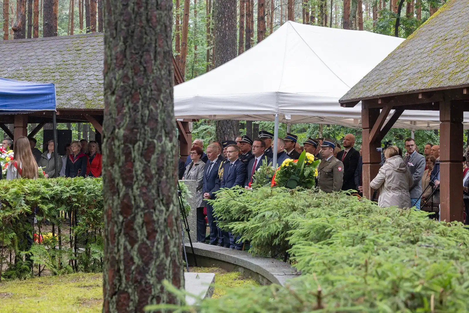 Uczestnicy stoją pod namiotem
