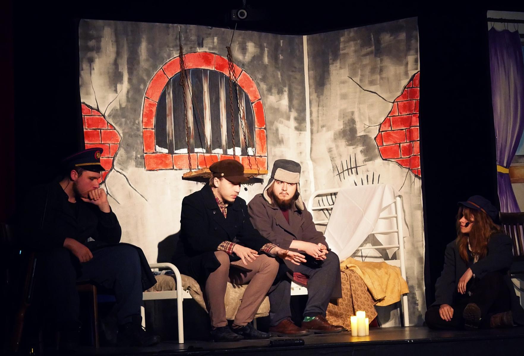 Na scenie siedzi trzech mężczyzn