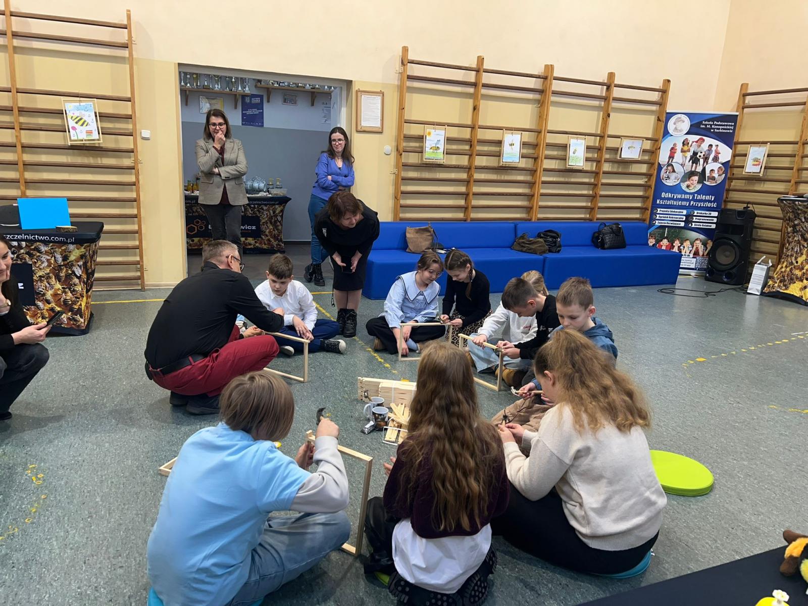 Uczniwoie siedzą w okręgu wykonują jakieś zadanie