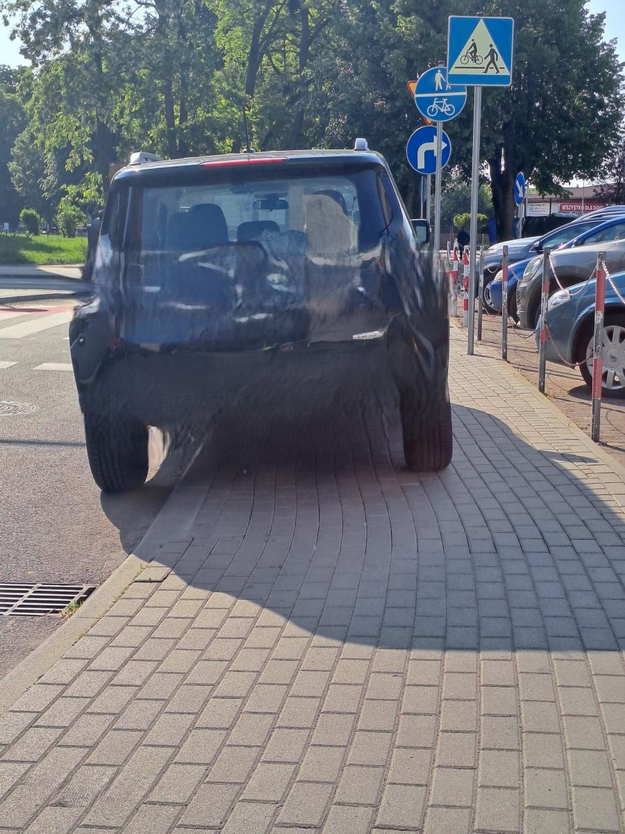 Samochód osobowy czarny stoi na chodniku