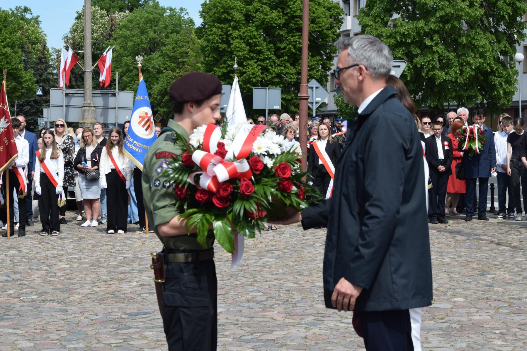 Burmistrz Dębna przekazuje kwiaty dla harcerza
