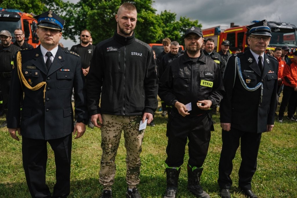Stoją strażacy podczas dekoracji