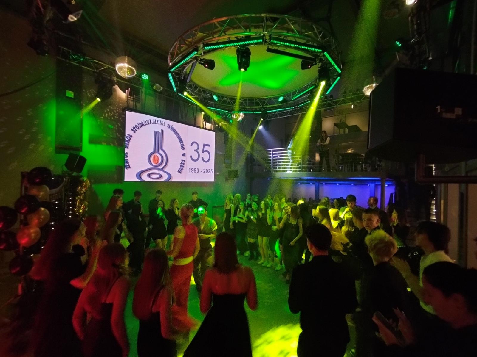 Dyskoteka młodzież w przyciemnionej oświetlonej różnymi kolorami  