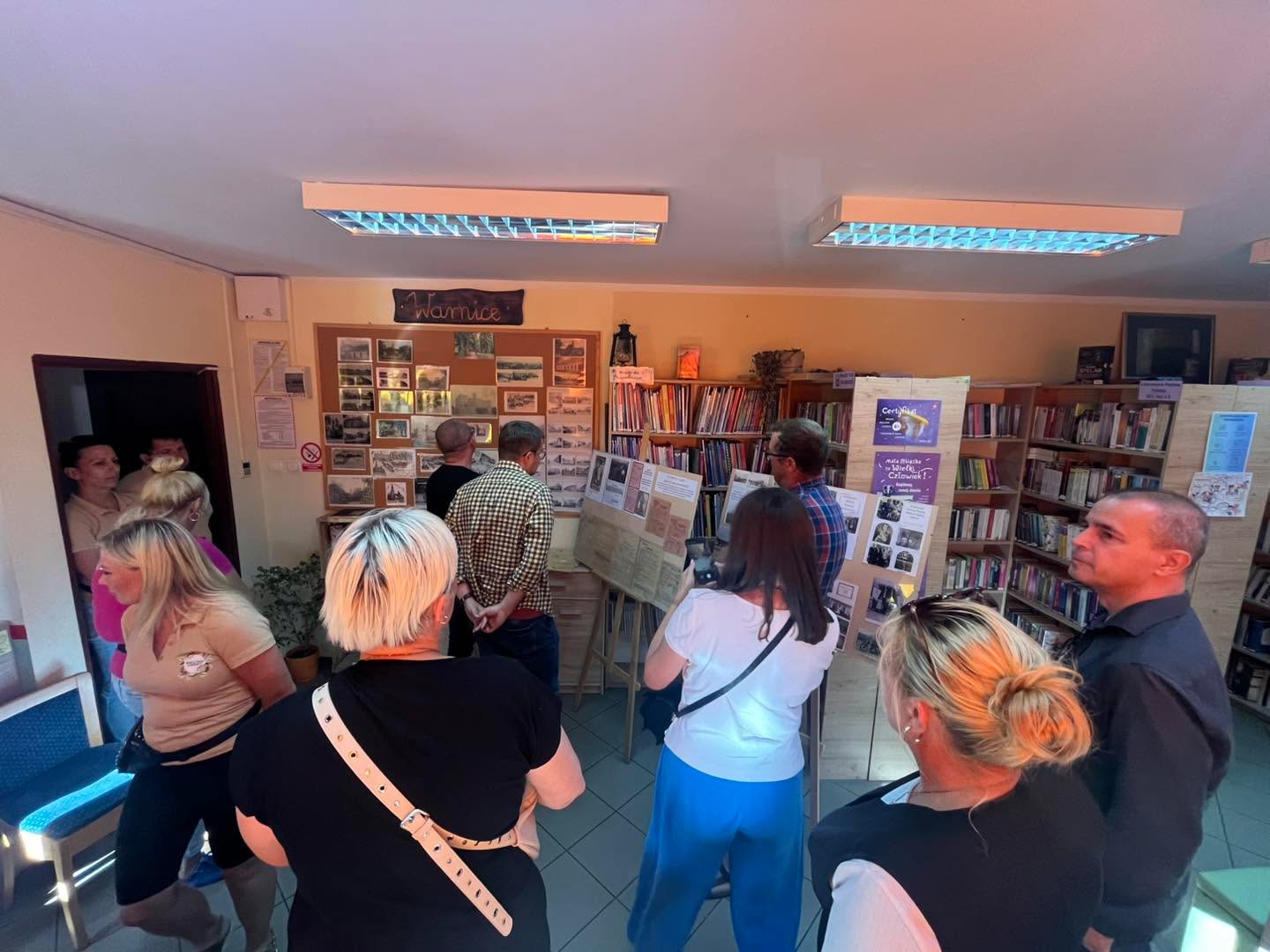 Komisja w bibliotece ogląda zdjęcia i dokumenty