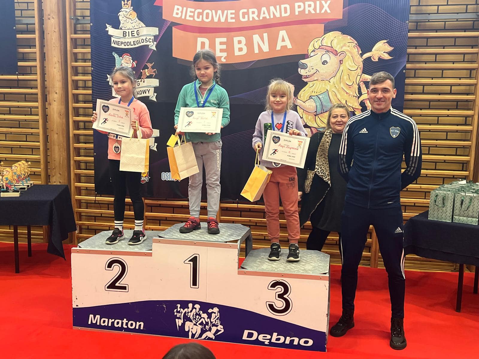 Trzy dziewczynki stoją na podium