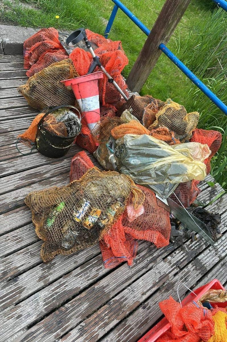 Zebrane śmieci w pomarańczowych workach leżą na pomoście 