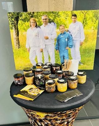Stoisko Centrum Łukasiewicz, na stoliku leżą słoiki z miodem 