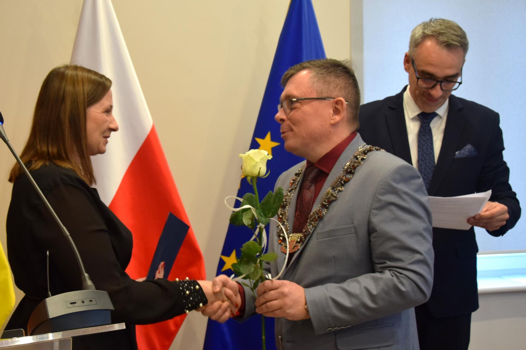 przewodniczący rady wręcza różę nauczucielce
