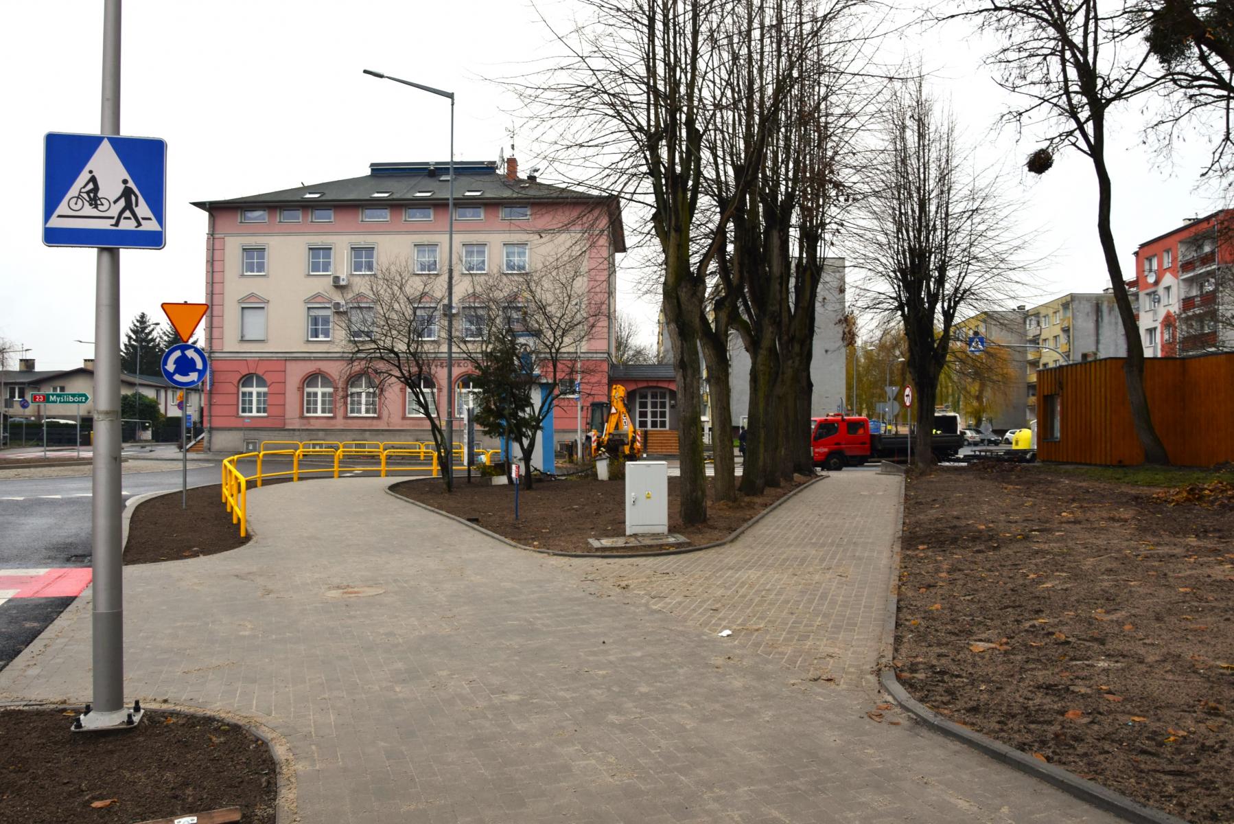 Chodniki, barierki, drzewa, budynke wielorodzinny