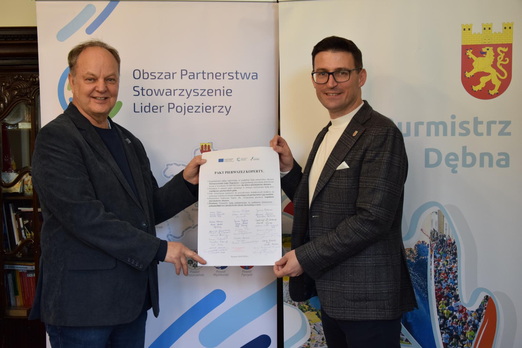 Od lewej: Irek Kostka, Grzegorz kulbicki, trzymają podpisany pakt