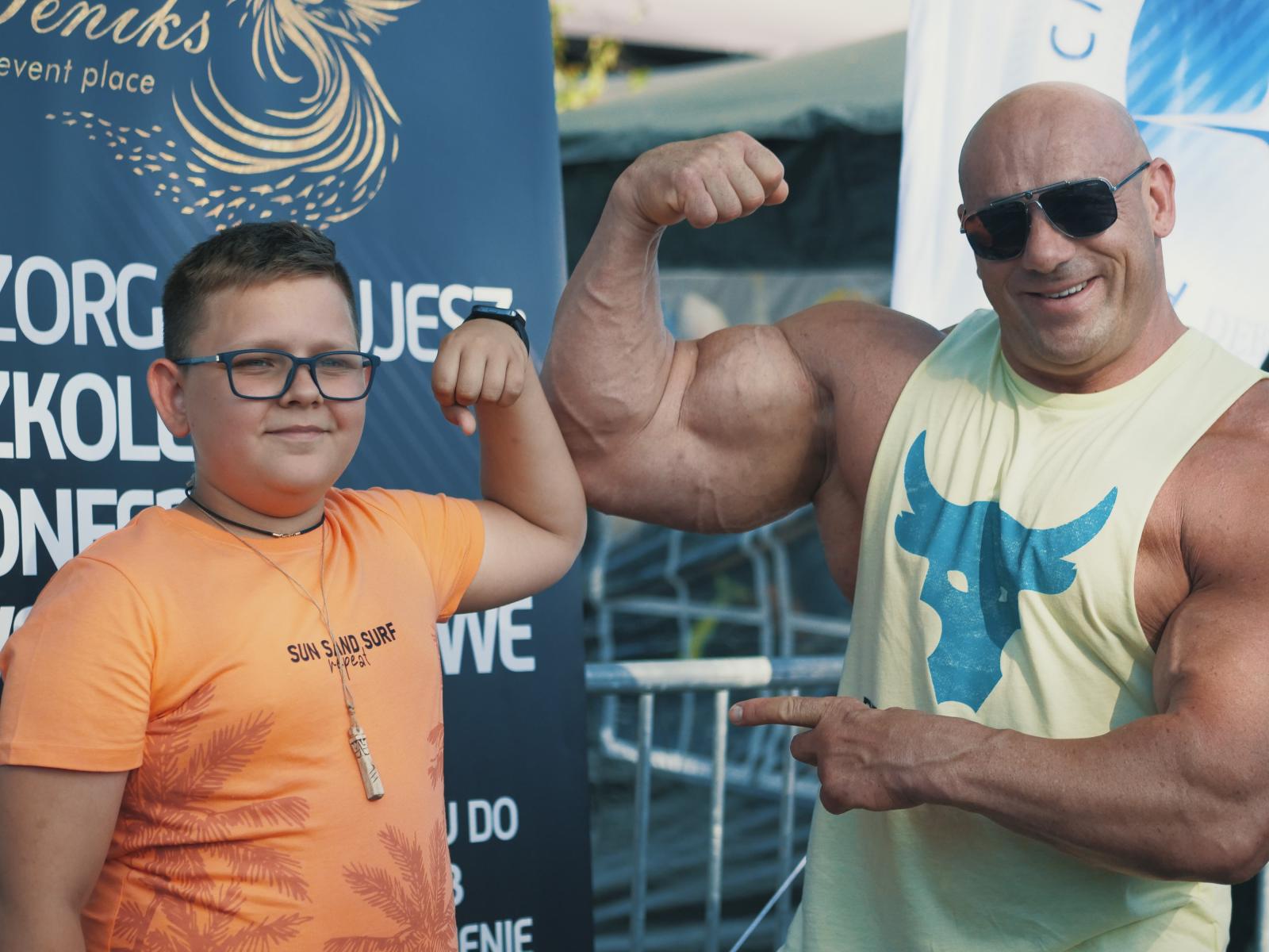 Chłopiec z  siłaczem pokazują bicepsy