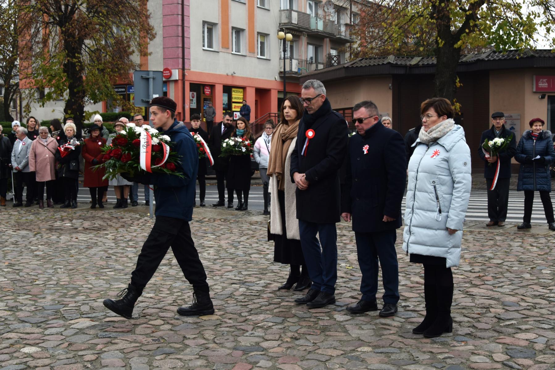 Delegacja samorządu, od lewej: sekretarz gminy, przewodniczący rady, burmistrz Dębna, zastępca burmistrza. przed nimi z wieńcem idzie harcerz