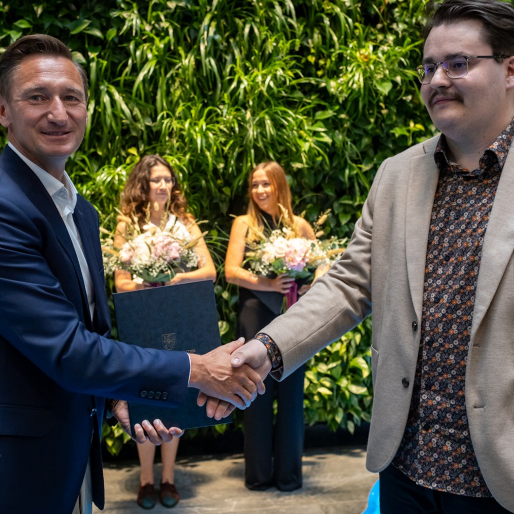 Od lewej stoi Michał, po prawej marszałek województwa. Ściskają sobie dłoń