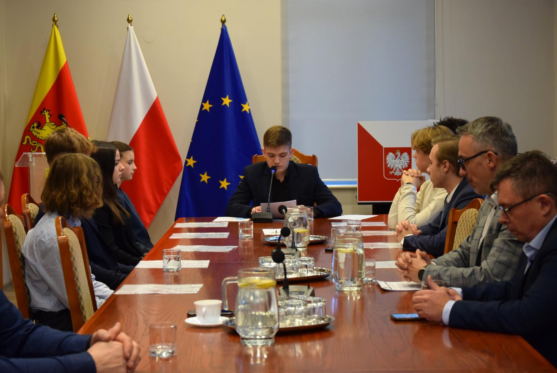 Młodzi radni siedzą przy stole prezydialnym