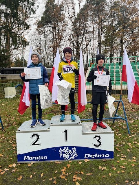 Trzech chłopców stoi na podium 