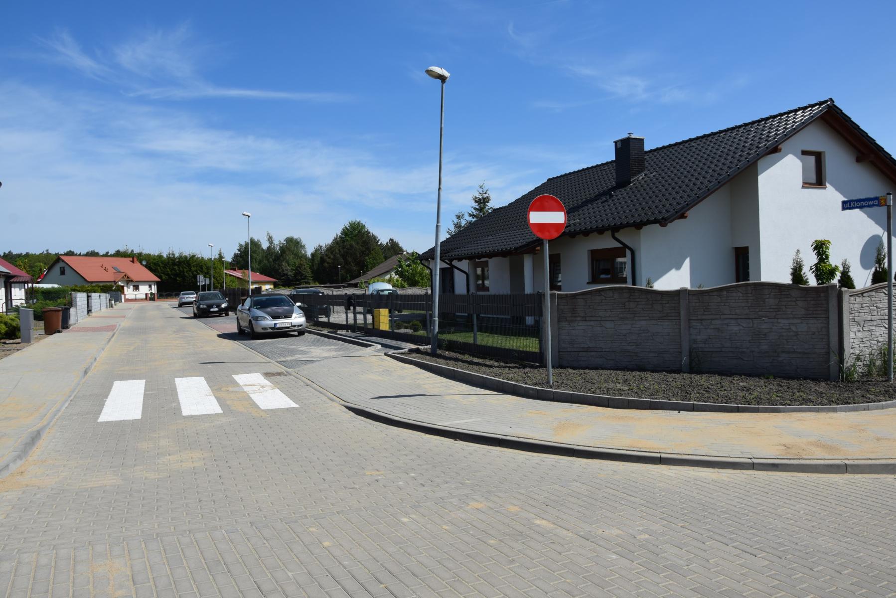 Ulica Klonowa, po obu stronach domy, na początku znak zakaz wjazdu