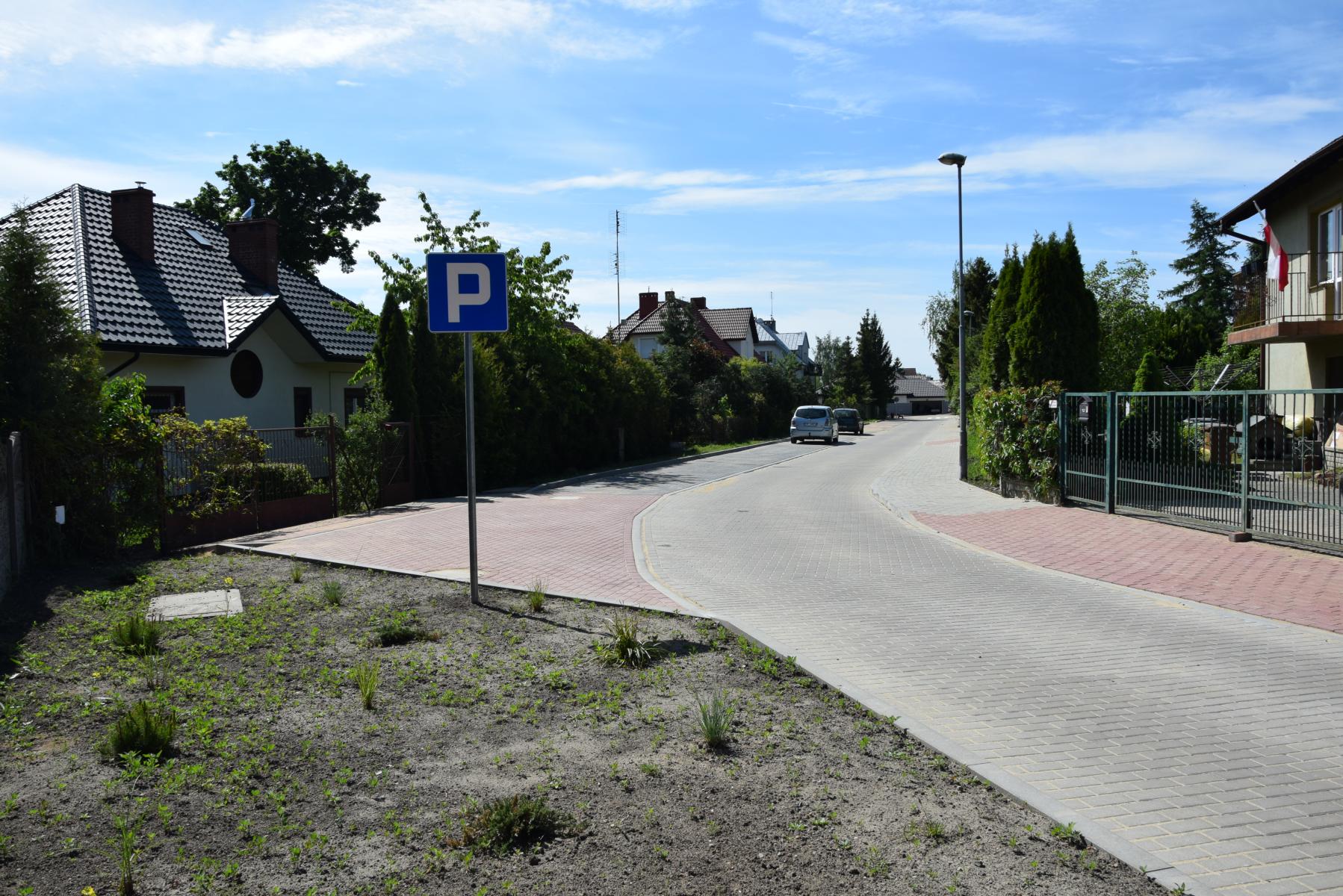 Ulica Akacjowa, po obu stronach domu, zielone krzewy, ogrodzenia 