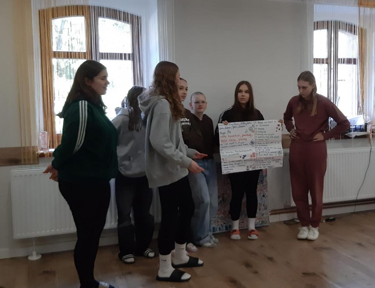 Uczennice w grupce. Jedna trzyma plakat