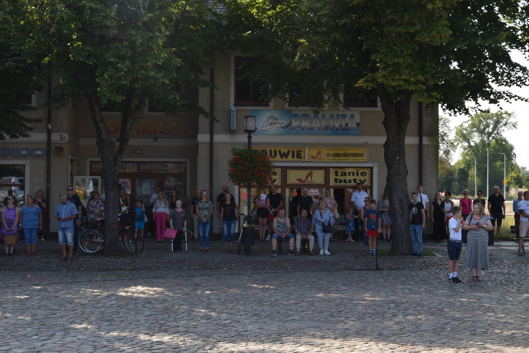 Zgromadzeni mieszkańcy stoją na placu