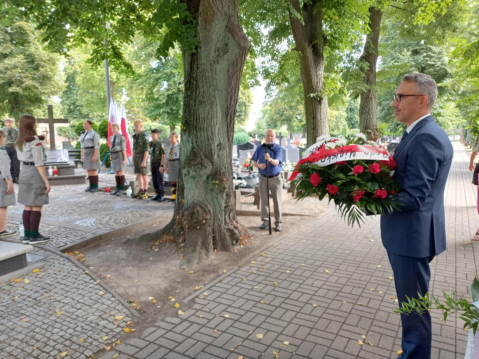 Burmistrz stoi z kwiatami