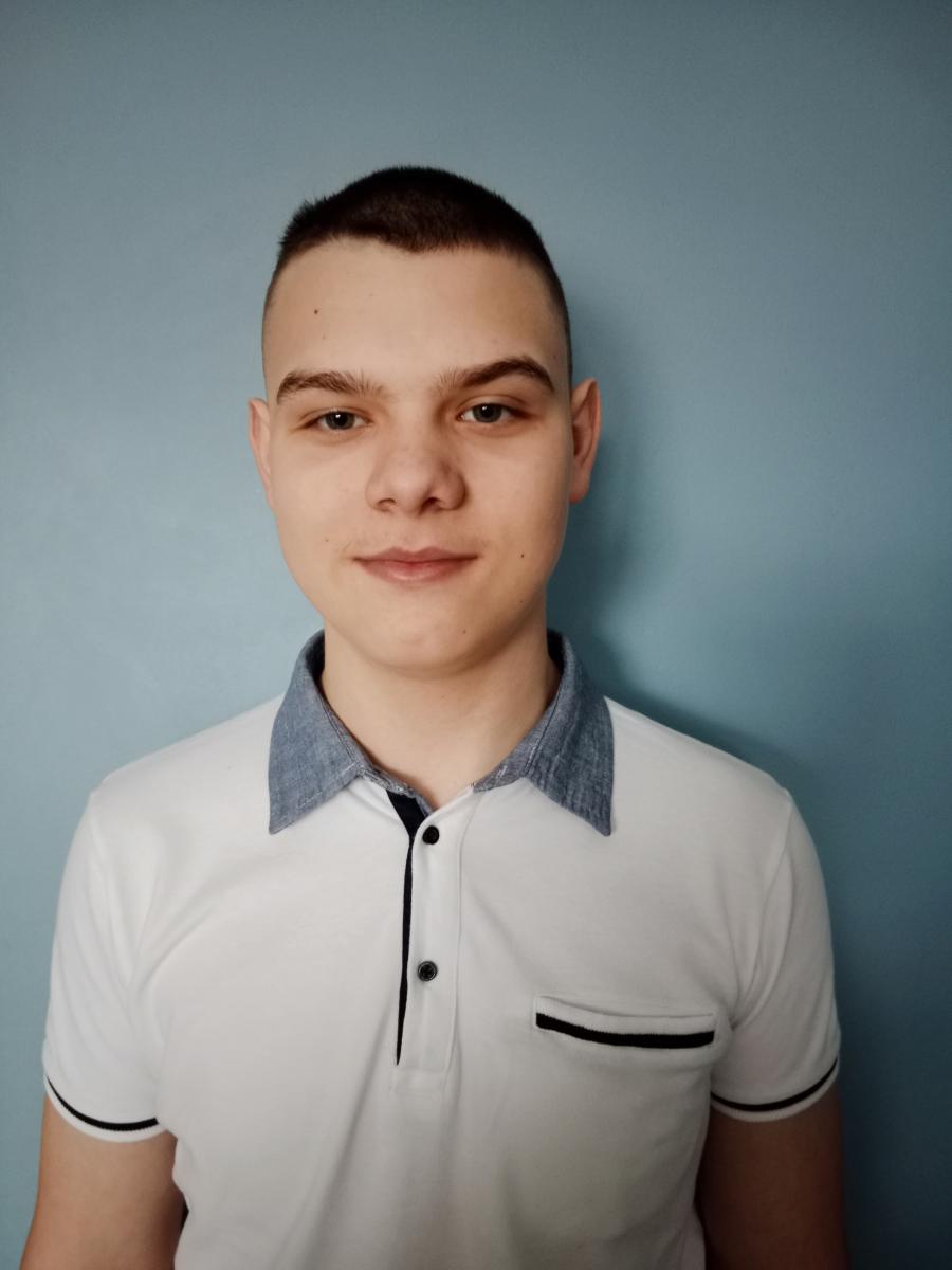 Młody chlopak, uczeń SP Sarbinowo, tło niebieskie 