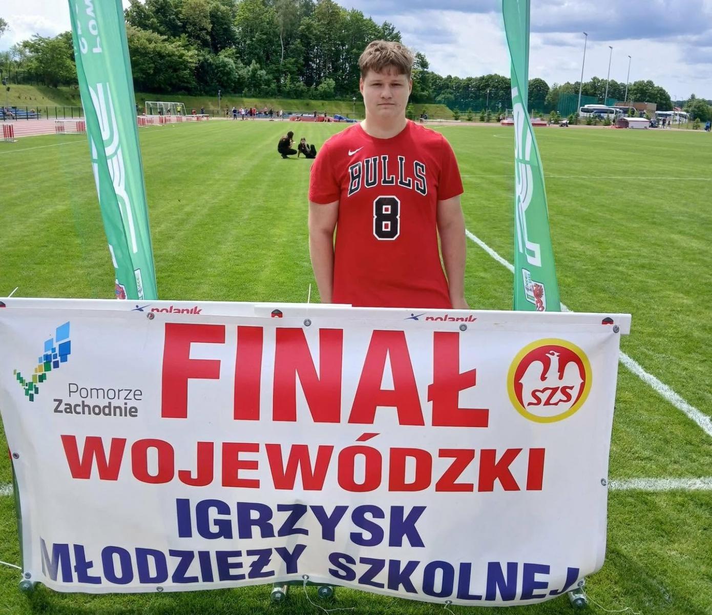 Uczeń SP2 Dębno na stadionie, przed nim stoi baner z napisem Finał Wojewódzki