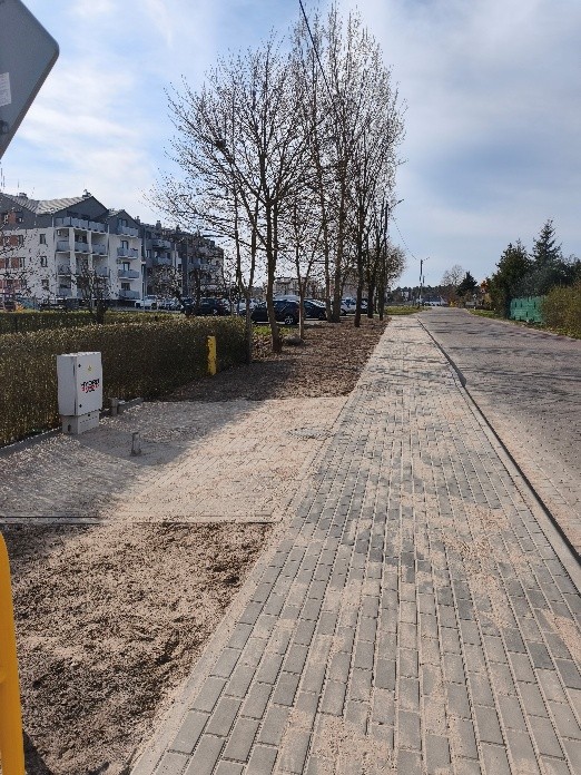 Nowy chodnik z kostki , w tle (po lewej stronie) budynek wielorodzinny 