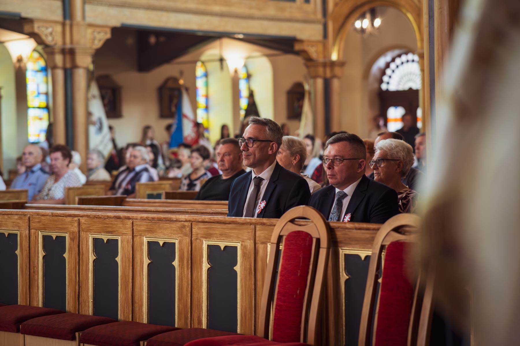 Ludzie siedzą w ławkach kościelnych