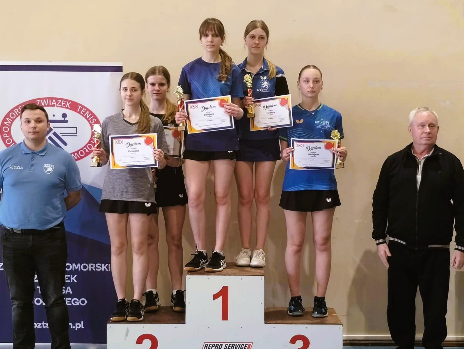 Zawodnicy stoją na podium. Na najwyższym Julia z koleżanką 