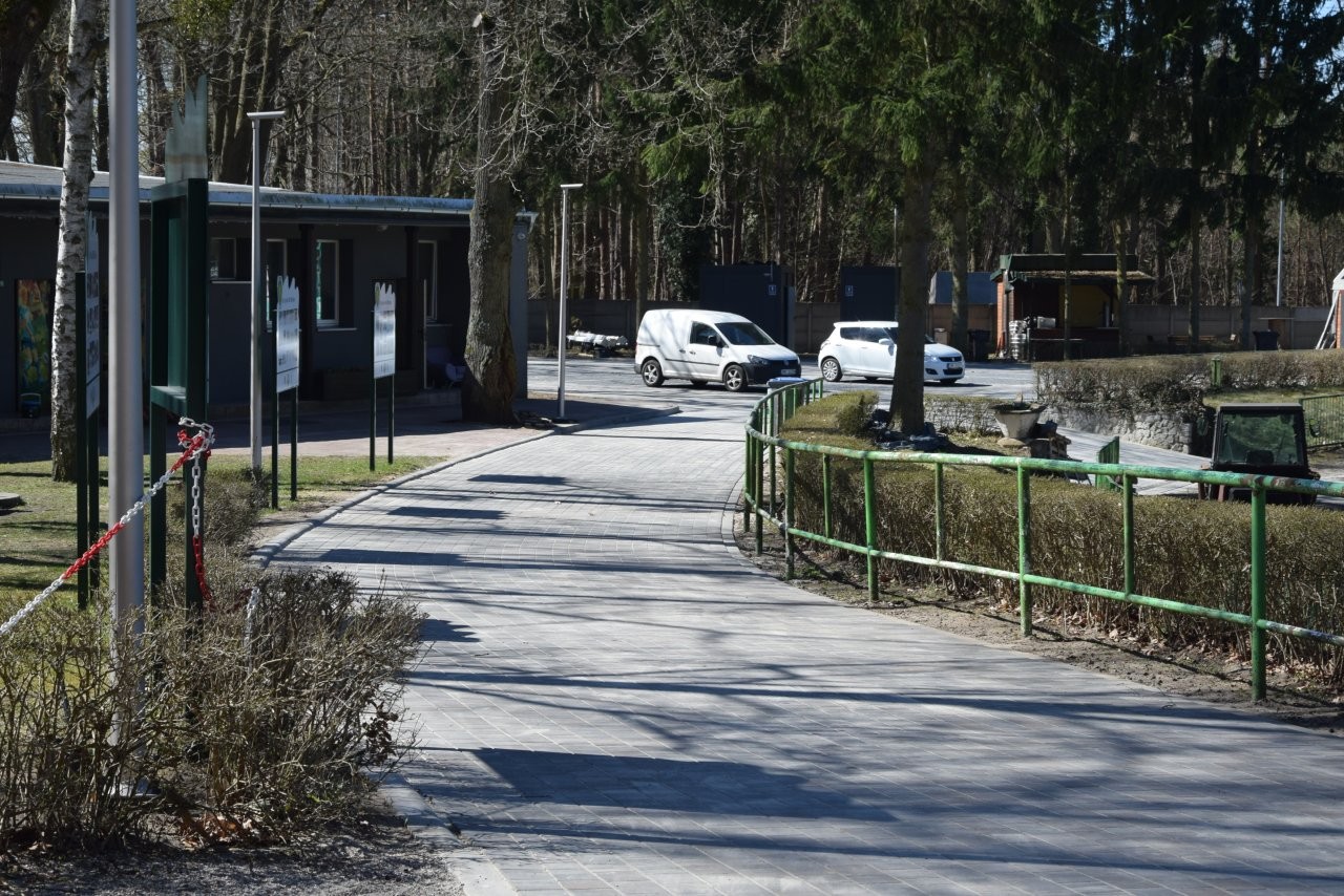 Utwardzony chodnik, w tle po lewej budynek szatni 