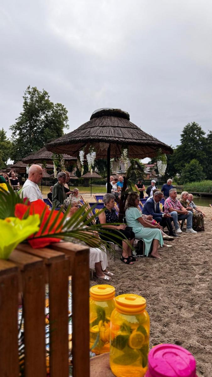 Goscie siedzą na krzesełkach na plaży