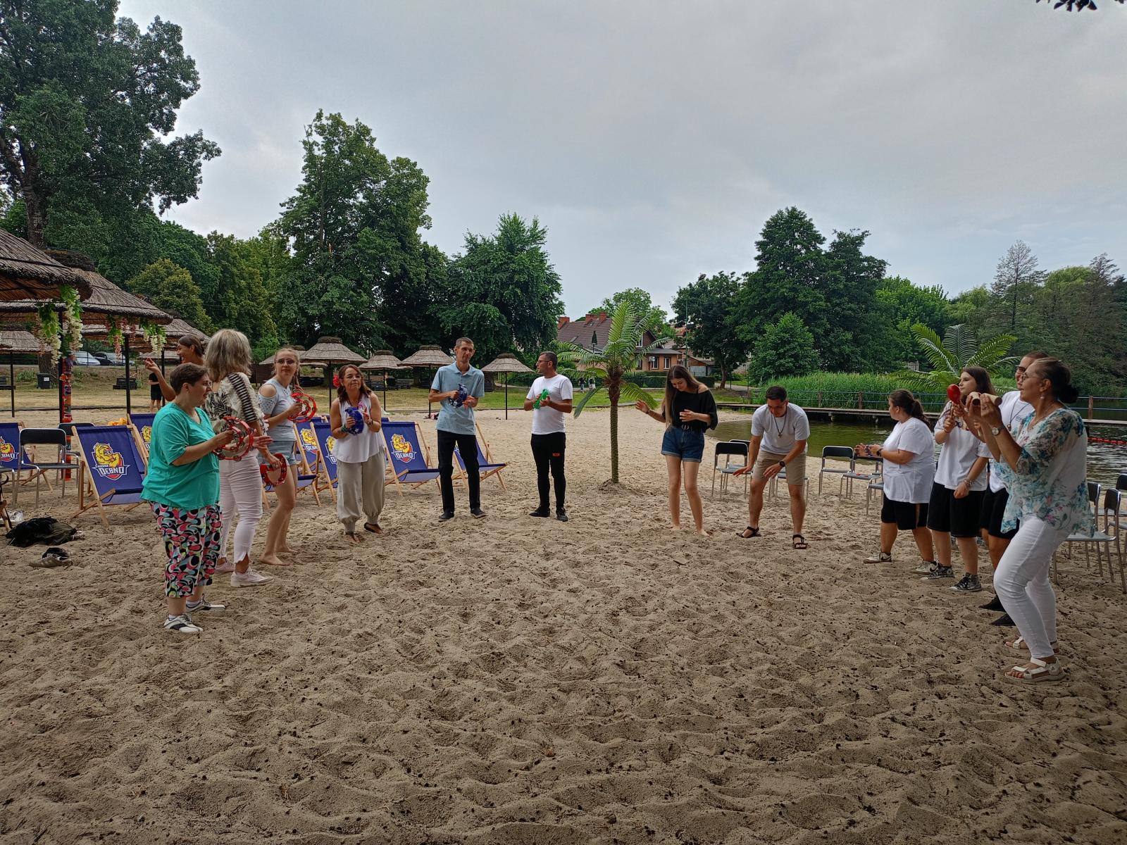 Uczestnicy w ruchu tańczą na plaży