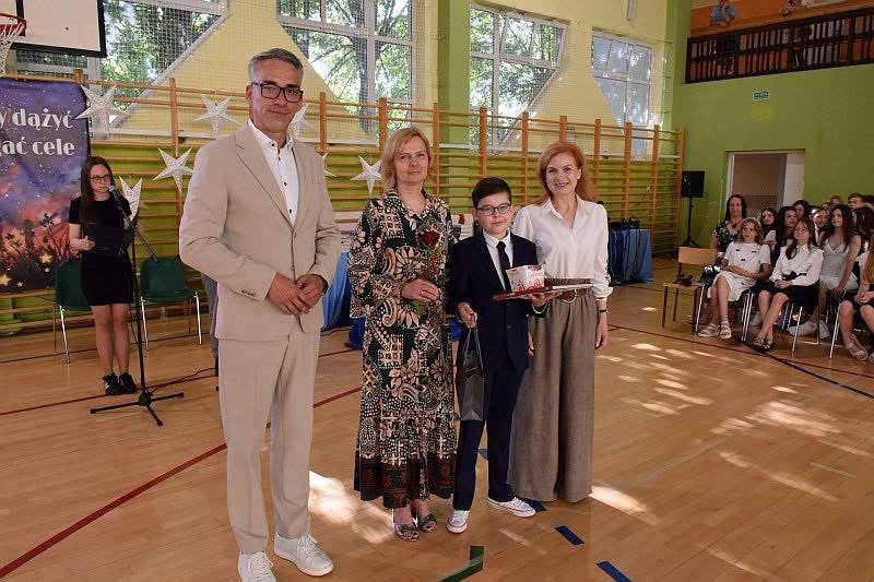 od lewej na hali stoją: burmistrz Dębna, pani nauczycielka, chłopiec i pani dyrektor 