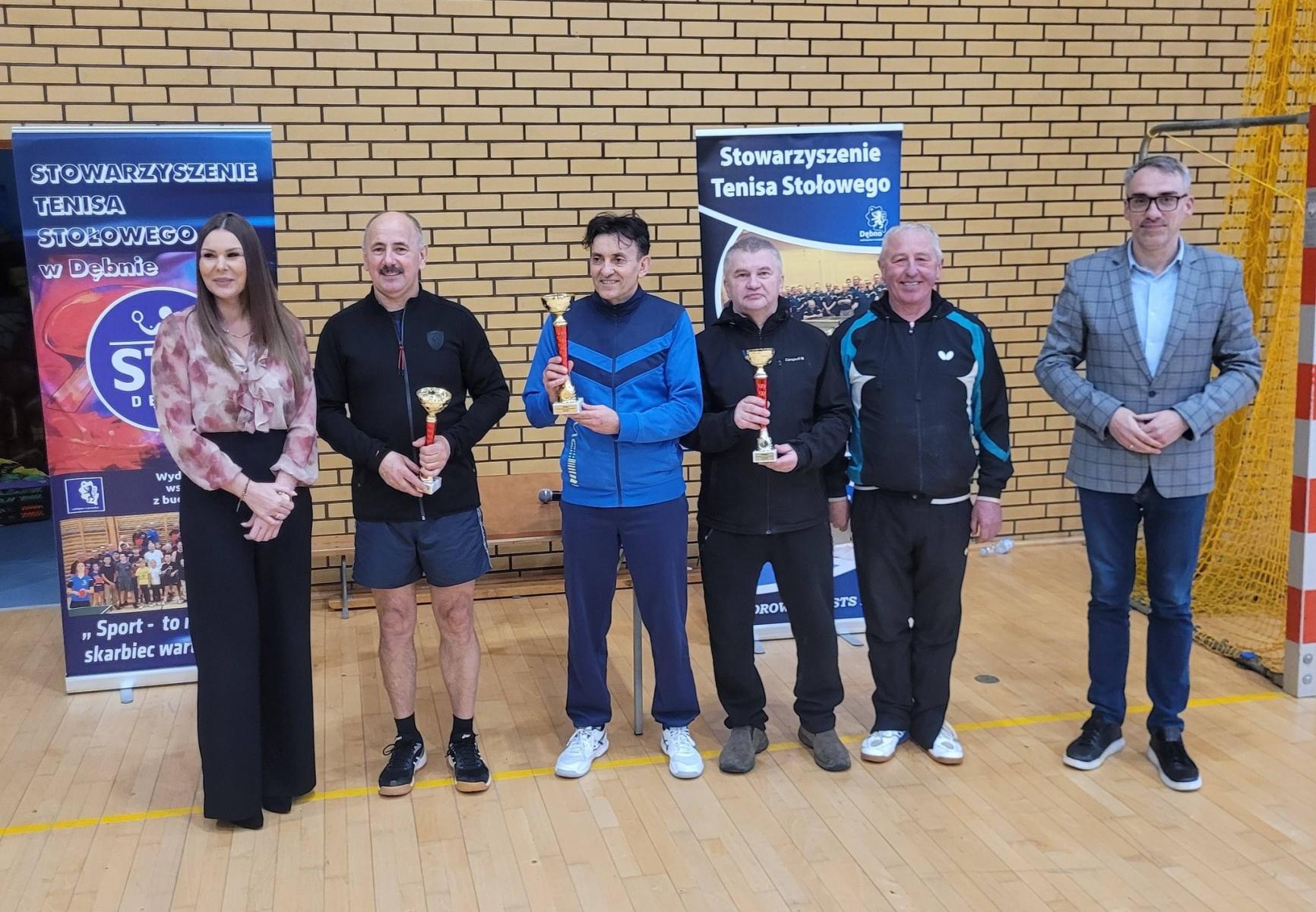 Na hali od lewej stoją: pani dyrektor, trzech mężczyzn z pucharmi w rękach, prezes STS i burmistrz